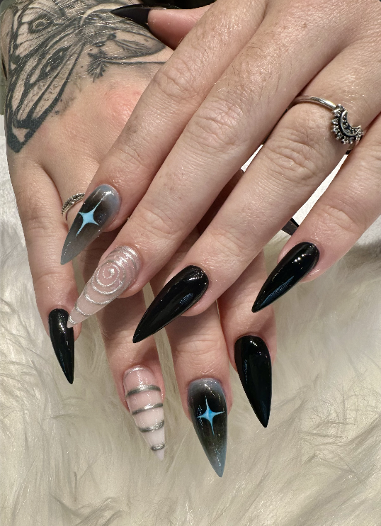 Black stiletto nails with celestial star accents
