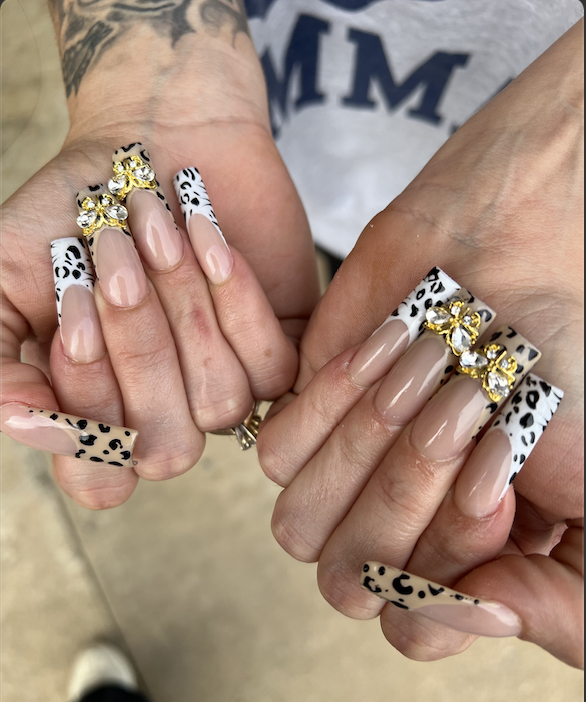 Leopard print french tip nails with gold and crystal charms